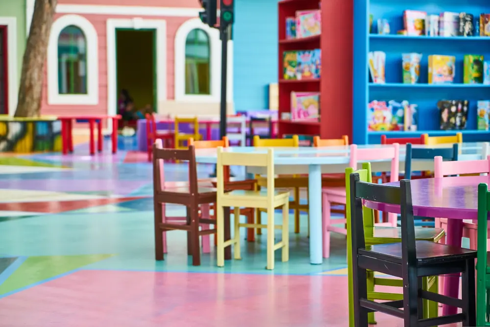 Bright classroom with colorful tables, chairs and bookshelves